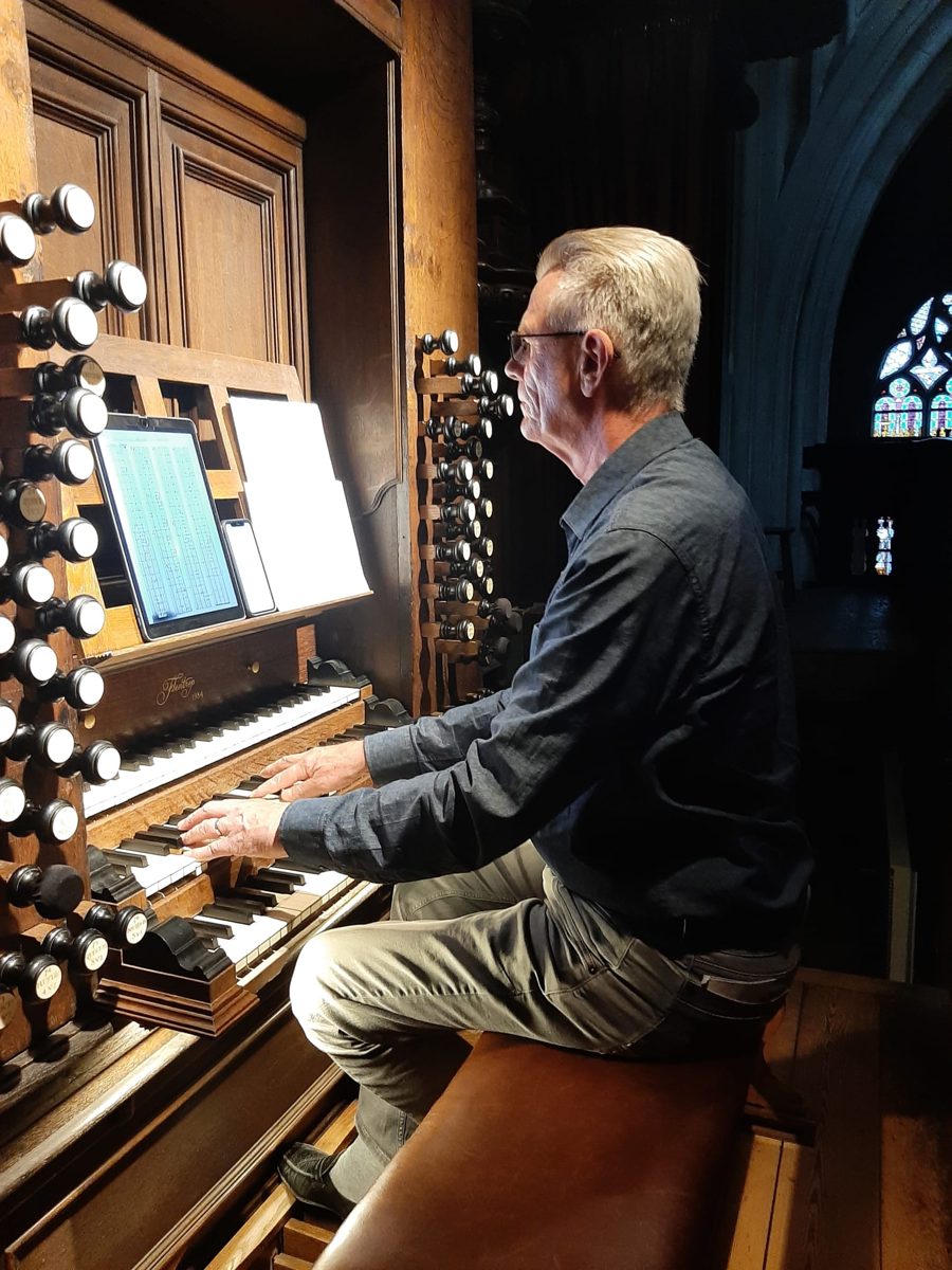 Hans Latour playing the organ of the Sint-Jan in 's-Hertogenbosch, a tablet on the music desk